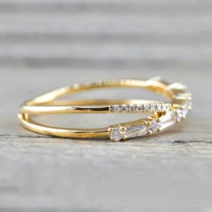 Close-up of gold double row crisscross ring with micro-pave baguette and round zircon stones