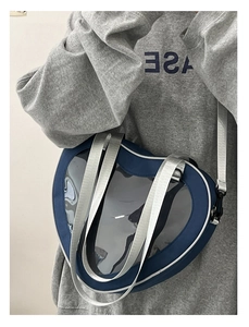 Close-up of heart-shaped transparent window on a blue ita-bag with silver chain strap
