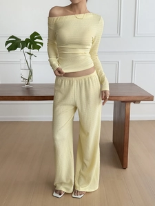 Detail showing the light yellow pleated fabric texture and drape of the two-piece lounge set