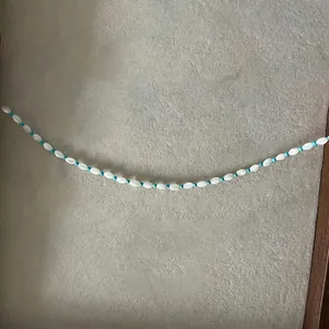 Détail du collier à perles de rocaille avec perles navettes blanches et turquoise