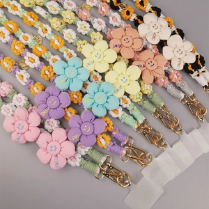 Handmade woven crossbody phone lanyard featuring cute colorful fabric daisy charms