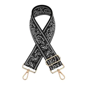 Close-up of black and white paisley jacquard bag strap with adjustable gold metal hardware