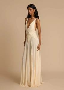 Close-up of intricate lace waist details and deep V-neck on a beige maxi dress