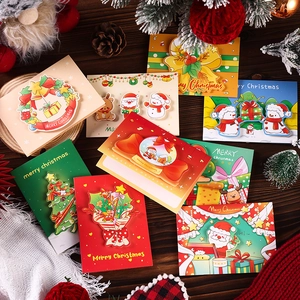 Flat lay of creative 3D pop-up Christmas cards on rustic wood with festive decor