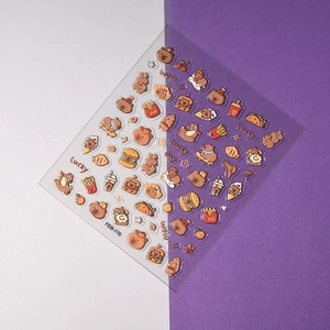 Detailed view of 3D embossed nail stickers with cartoon bear and fast food patterns
