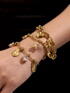 Detailansicht des mehrlagigen 18k vergoldeten Armband-Sets mit Bär- und Herzanhängern