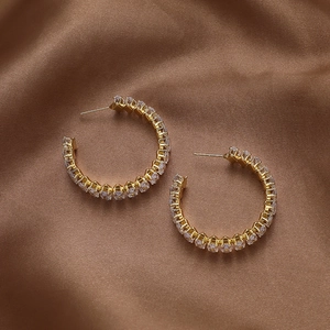 Macro shot of gold geometric hoop earrings with sparkling pavé cubic zirconia inlay
