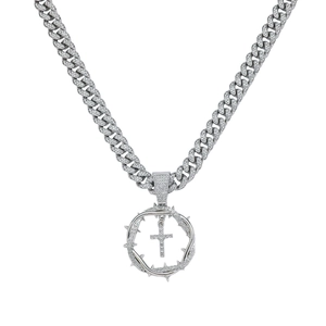Close-up of silver Cuban link chain with a diamond-encrusted thorn cross pendant