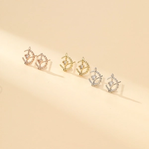 Three pairs of heart-arrow earrings in rose gold, gold, and silver finishes with cubic zirconia