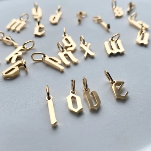 Macro shot of gold Old English letter charms spelling LOVE with polished metal finish