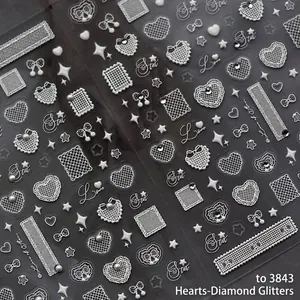 3D white embossed lace heart nail stickers with rhinestones and bows on dark background
