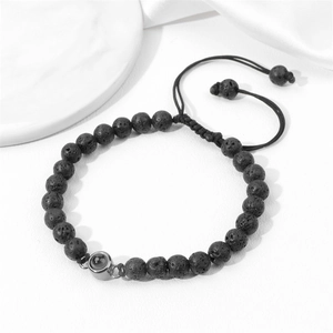 Detail of black lava stone beads with a metal projection bead on woven rope bracelet