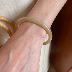 Close-up of translucent amber resin bangle with natural texture on female wrist