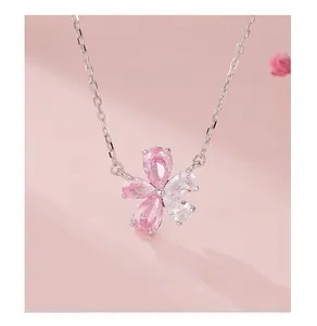 Macro shot of silver five-petal flower pendant with pink and white cubic zirconia