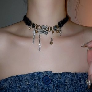 Macro detail of plush star choker with rhinestone bear pendant and metal fringe chains