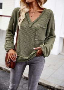 Detail of olive green V-neck waffle knit top with long sleeves and front chest pocket