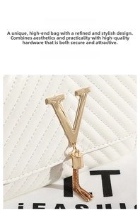 Close-up of a white quilted shoulder bag featuring a gold V-clasp and metallic tassels
