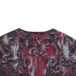 Detail of round neckline and red-blue quilted pattern on light faux suede jacket