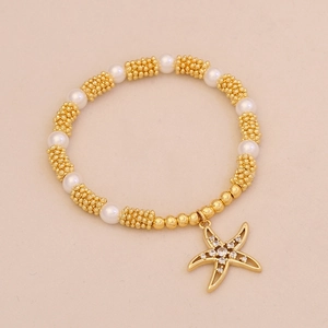 Starfish pendant pearl bracelet with golden beads and rhinestones on beige background