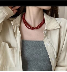 Gros plan sur un collier de perles rouge foncé à double couche au look vintage