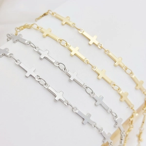 Detailed macro view of cross-shaped link chains in gold and silver metallic finishes