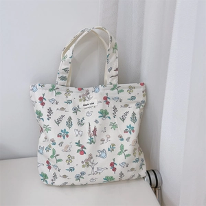 Detail of cream canvas tote bag featuring colorful animal prints and simple wish label