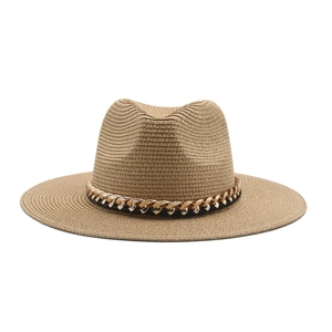 Detail of hand-woven straw texture and black-gold chain decoration on a Panama hat