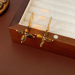 Detail of vintage flower earrings with tiger eye stone on gold plated spiral hooks