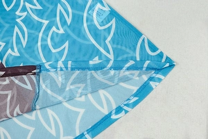 Gros plan détaillé du tissu en maille bleue avec motif flamme et étiquette Lucky