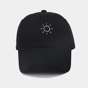 Detailed close-up of a black cotton baseball cap with white embroidered sun pattern