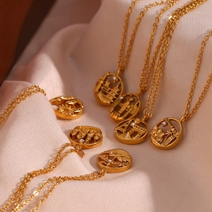 Macro shot of 18K gold-plated world landmark necklaces on beige silk background