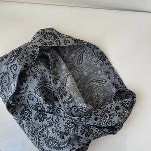 Detailed macro view of the grey paisley pattern on the linen tote bag surface