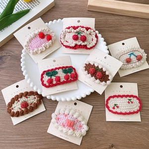 Barrettes à cheveux tricotées main cerise et fraise sur un plateau décoratif