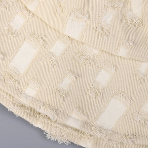Vue macro du tissu beige d'un bob avec détails effilochés et texture de tissage en sergé