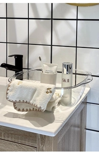 Close-up of a transparent minimalist washbasin with integrated handles in a modern bathroom