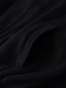 Detailansicht der schwarzen Strickstruktur und der Taschennähte an der Bomberjacke