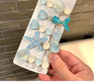 Close-up of 5-piece marine theme resin hair clips with blue glitter and pearls
