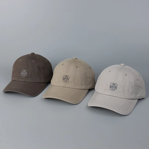 Detailed embroidery of SINDUYA 1985 logo on multiple cotton baseball cap colors