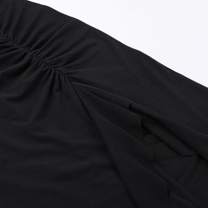 Détail d'une robe noire montrant la texture froncée du tissu et les plis élégants