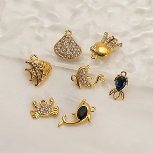 Pendentifs animaux marins dorés sertis de cristaux avec dauphins et crabes sur verre ondulé