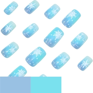 Unghie finte blu sfumate con motivi di fiocchi di neve bianchi e glitter argentati