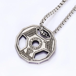 Macro shot of silver dumbbell weight plate necklace with engraved fitness motivation text