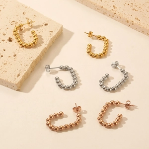 Detailed view of C-shaped quilted hoop earrings in gold, silver, and rose gold finishes