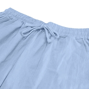 Macro view of light blue linen trousers with elastic waistband and drawstring detail