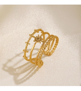Détail d'une bague étoile plaquée or 18 carats sur fond de soie blanc cassé