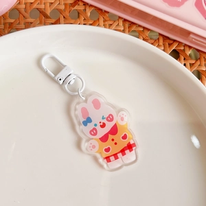 Close-up of a cute acrylic rabbit keychain with a blue bow and white metal lobster clasp