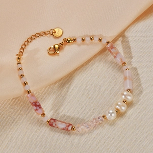 Detail of a gold stainless steel bracelet with pink marble beads and natural pearls