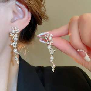 Detailed view of long pearl fringe earrings featuring butterfly cubic zirconia and gold plating