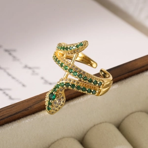 Gold plated snake ring with green and clear zircon crystals in a beige velvet jewelry box