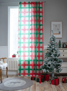 Detail of red and green plaid Christmas curtain in a cozy festive home setting